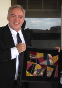 Eric Elder holding a quilt made by Marge Albrecht